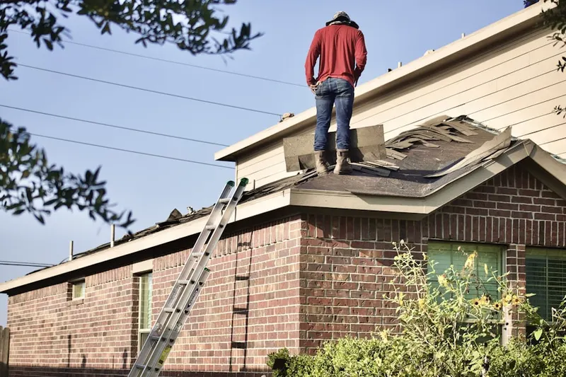 Professional roofer working on a residential roof in Mid-Westside
